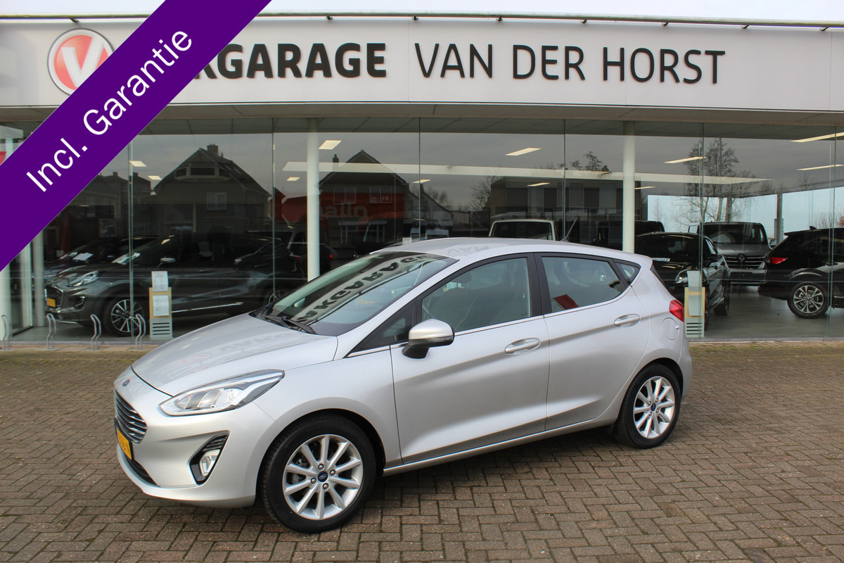 Ford Fiesta 1.0-100pk EcoBoost Titanium 5drs. Uiterst nette, luxe en zuinige Ford Fiesta. Voalautm. airco, Cruise control, Navigatie, LM wielen, Metallic lak, Parkeersensoren achter, Telefoonvoorb., Lane assist etc. Ford Fiesta 1.0-100pk EcoBoost Titanium 5drs. Uiterst nette, luxe en zuinige Ford Fiesta. Voalautm. airco, Cruise control, Navigatie, LM wielen, Metallic lak, Parkeersensoren achter, Telefoonvoorb., Lane assist etc.