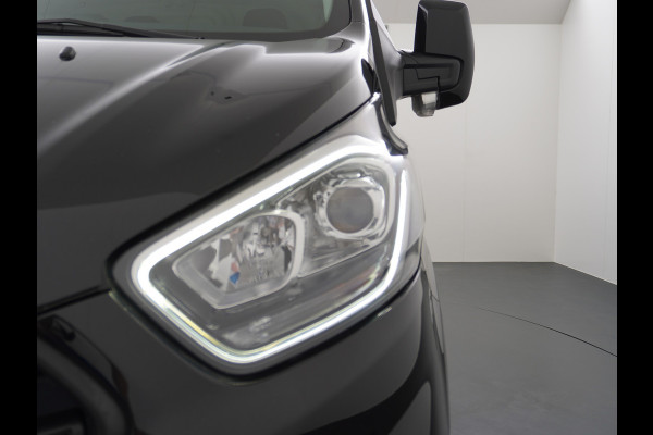 Ford Transit Custom 2.0TDCI 130PK 3-persoons Airco PDC Trekhaak Cruise-Controle Adaptieve bochtverlichting Voorruit Verwarmbaar Betonplex Schuifdeur Projector-koplamp mistlampen regen-/lichtsensor Zeer Compleet! EURO 6 385Nm 2.500kg Trekvermogen!