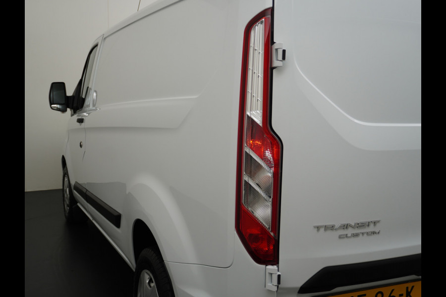 Ford Transit Custom 280 2.0TDCI 130PK L1H1 3-Persoons Apple Carplay Android Auto Airco Trekhaak Camera Cruise Control Pdc Voorruitverwarming Trend Regen-Lichtsensor Betonplex Vloer Wandbetimmering Schuifdeur Euro 6 385NM Koppel Zeer Compleet!