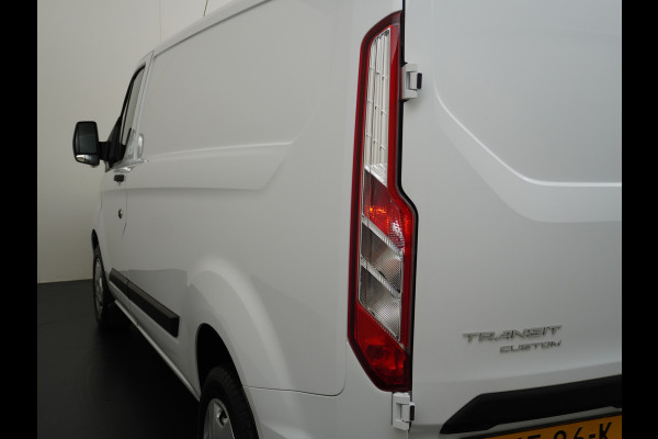 Ford Transit Custom 280 2.0TDCI 130PK L1H1 3-Persoons Apple Carplay Android Auto Airco Trekhaak Camera Cruise Control Pdc Voorruitverwarming Trend Regen-Lichtsensor Betonplex Vloer Wandbetimmering Schuifdeur Euro 6 385NM Koppel Zeer Compleet!