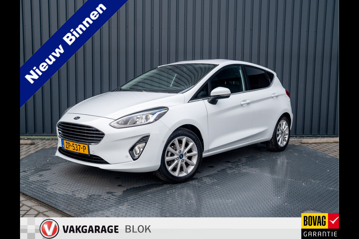 Ford Fiesta 1.0 EcoB. Aut. Titanium | Trekhaak | Stoel & Stuur verw. | Camera | Navi | PDC V&A | Prijs Rijklaar!! Ford Fiesta 1.0 EcoB. Aut. Titanium | Trekhaak | Stoel & Stuur verw. | Camera | Navi | PDC V&A | Prijs Rijklaar!!