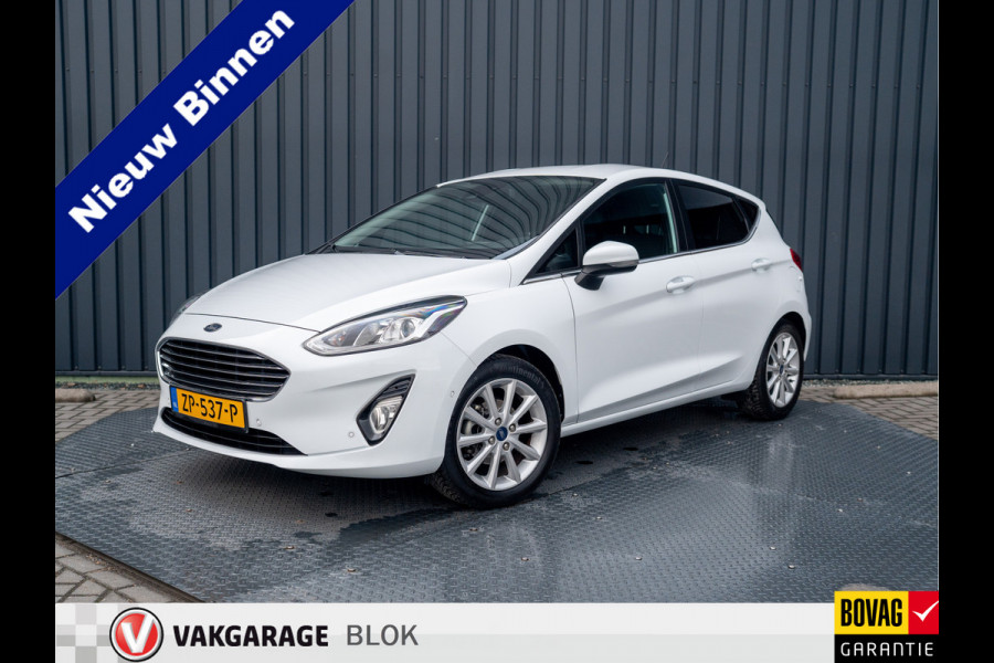Ford Fiesta 1.0 EcoB. Aut. Titanium | Trekhaak | Stoel & Stuur verw. | Camera | Navi | PDC V&A | Prijs Rijklaar!! Ford Fiesta 1.0 EcoB. Aut. Titanium | Trekhaak | Stoel & Stuur verw. | Camera | Navi | PDC V&A | Prijs Rijklaar!!