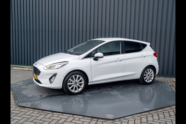 Ford Fiesta 1.0 EcoB. Aut. Titanium | Trekhaak | Stoel & Stuur verw. | Camera | Navi | PDC V&A | Prijs Rijklaar!! Ford Fiesta 1.0 EcoB. Aut. Titanium | Trekhaak | Stoel & Stuur verw. | Camera | Navi | PDC V&A | Prijs Rijklaar!!