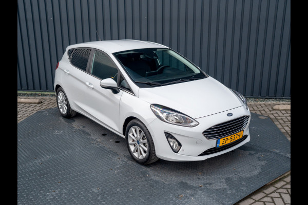 Ford Fiesta 1.0 EcoB. Aut. Titanium | Trekhaak | Stoel & Stuur verw. | Camera | Navi | PDC V&A | Prijs Rijklaar!! Ford Fiesta 1.0 EcoB. Aut. Titanium | Trekhaak | Stoel & Stuur verw. | Camera | Navi | PDC V&A | Prijs Rijklaar!!