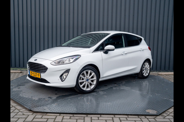 Ford Fiesta 1.0 EcoB. Aut. Titanium | Trekhaak | Stoel & Stuur verw. | Camera | Navi | PDC V&A | Prijs Rijklaar!! Ford Fiesta 1.0 EcoB. Aut. Titanium | Trekhaak | Stoel & Stuur verw. | Camera | Navi | PDC V&A | Prijs Rijklaar!!