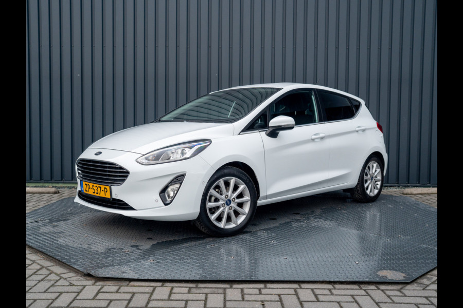 Ford Fiesta 1.0 EcoB. Aut. Titanium | Trekhaak | Stoel & Stuur verw. | Camera | Navi | PDC V&A | Prijs Rijklaar!! Ford Fiesta 1.0 EcoB. Aut. Titanium | Trekhaak | Stoel & Stuur verw. | Camera | Navi | PDC V&A | Prijs Rijklaar!!
