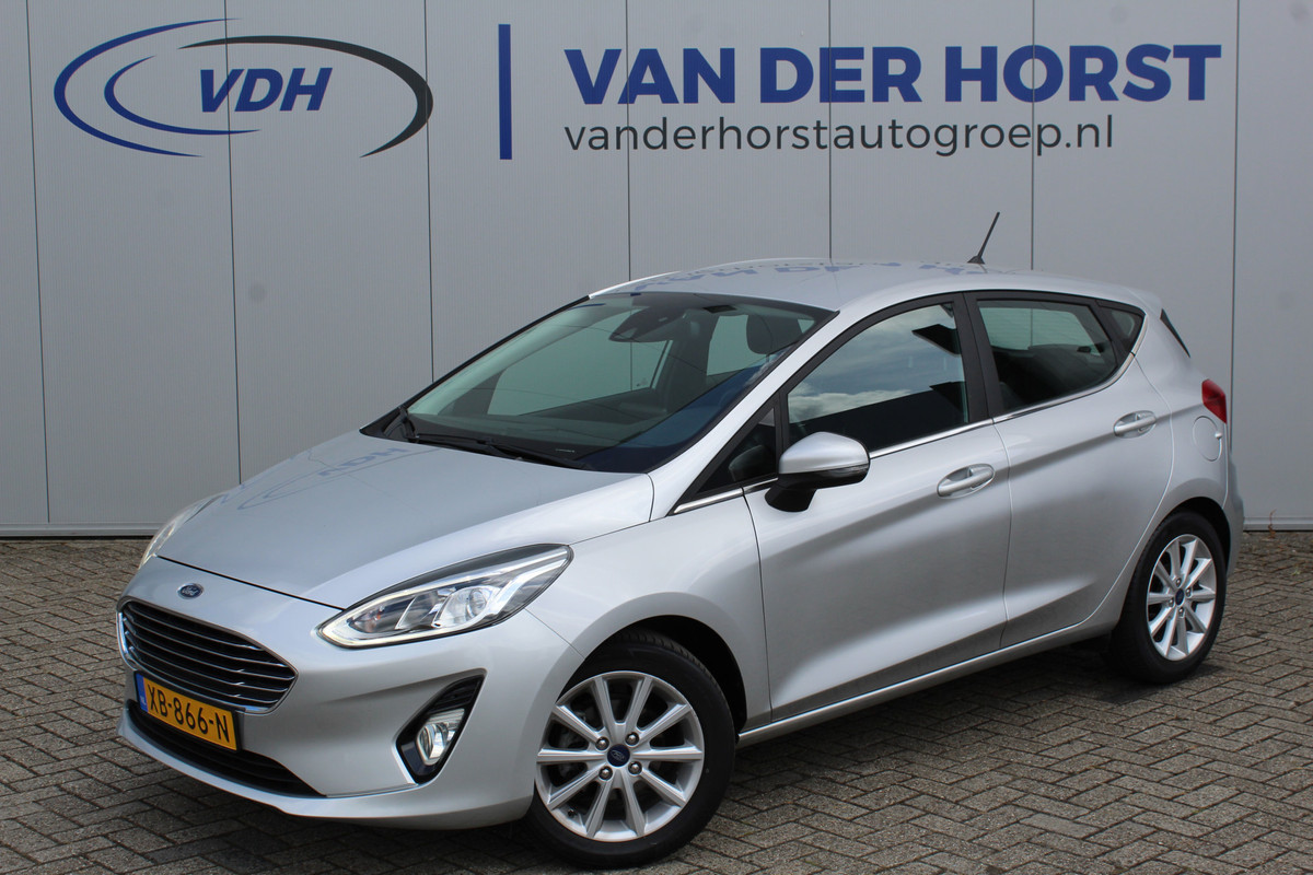 Ford Fiesta 1.0-100pk EcoBoost Titanium 5drs. Uiterst nette, luxe en zuinige Ford Fiesta. Voalautm. airco, Cruise control, Navigatie, LM wielen, Metallic lak, Parkeersensoren achter, Telefoonvoorb., Lane assist etc.