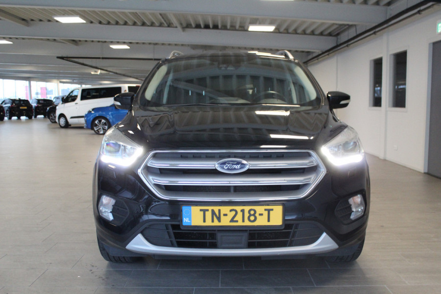 Ford Kuga 1.5-150pk EcoBoost Titanium. Nette Ford Kuga met een trekgewicht van maar liefst 2.000kg ! Autm. airco, stoel-, stuur- en voorraamverw., camera, parkeersensoren achter, navigatie, telefoonvoorb.,  17"LM wielen+all season banden, trekhaak, adapt. cruise cntrl etc.
