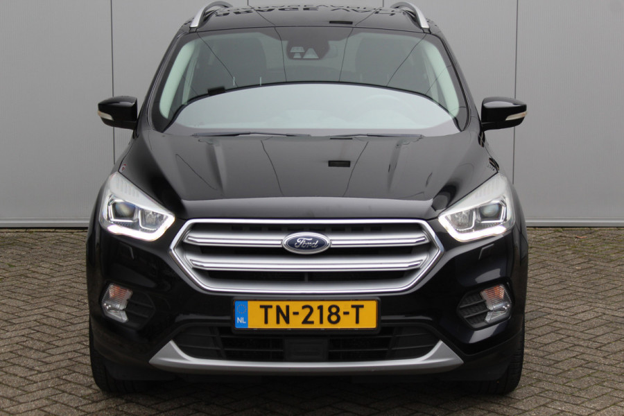 Ford Kuga 1.5-150pk EcoBoost Titanium. Nette Ford Kuga met een trekgewicht van maar liefst 2.000kg ! Autm. airco, stoel-, stuur- en voorraamverw., camera, parkeersensoren achter, navigatie, telefoonvoorb.,  17"LM wielen+all season banden, trekhaak, adapt. cruise cntrl etc.