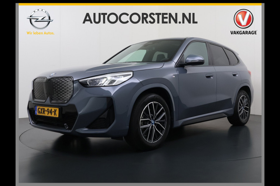 BMW iX1 eDrive20 67kWh M Sport pakket Pano-Dak/Schuif-dak Leer SOH 100% Warmtepomp Camera Navi Ecc PDC-a+v Apple Carplay Android Auto Elek.Achterklep Zwarte-Hemel VerkeersbordHerkenning WiFi M Aerodynamica  Lmv Led Privacy Glas Isofix DAB Keyless Wifi 1e Eigenaar Origineel Nederlandse Auto !!