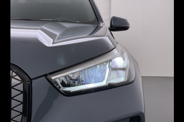 BMW iX1 eDrive20 67kWh M Sport pakket Pano-Dak/Schuif-dak Leer SOH 100% Warmtepomp Camera Navi Ecc PDC-a+v Apple Carplay Android Auto Elek.Achterklep Zwarte-Hemel VerkeersbordHerkenning WiFi M Aerodynamica  Lmv Led Privacy Glas Isofix DAB Keyless Wifi 1e Eigenaar Origineel Nederlandse Auto !!