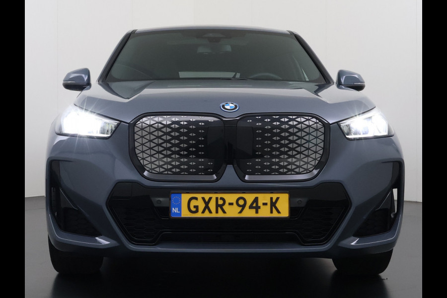 BMW iX1 eDrive20 67kWh M Sport pakket Pano-Dak/Schuif-dak Leer SOH 100% Warmtepomp Camera Navi Ecc PDC-a+v Apple Carplay Android Auto Elek.Achterklep Zwarte-Hemel VerkeersbordHerkenning WiFi M Aerodynamica  Lmv Led Privacy Glas Isofix DAB Keyless Wifi 1e Eigenaar Origineel Nederlandse Auto !!