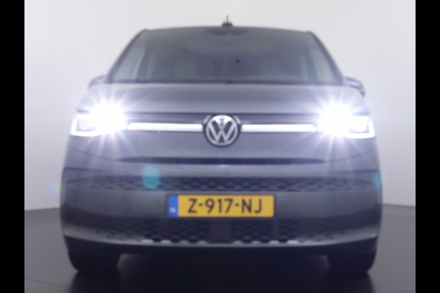 Volkswagen Multivan Bulli 218PK eHybrid AUT-6 Pano-Dak Navi 3-Zone Ecc Cruise Control Camera Trekhaak Apple Carplay Android Pdc Stoelverwarming Life 2+2+2 Premium Zitopstelling Keyless Lmv 19" Easy Open Pack Privacy Glas Elek.Achterklep Led Origineel Nederlandse Bus Dealeronderhouden 1.600kg trekvermogen
