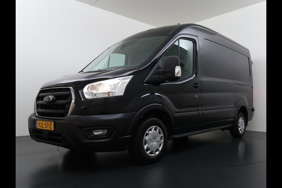 Ford Transit 310 2.0 TDCI L2H2 3-Persoons Camera Airco Stoelverwarming Elek.Stoel Cruise Control Pdc Lane Assist Trend Betonplex Vloer Wandbetimmering Schuifdeur Voorruitverwarming 1e Eigenaar Origineel Nederlandse Bus