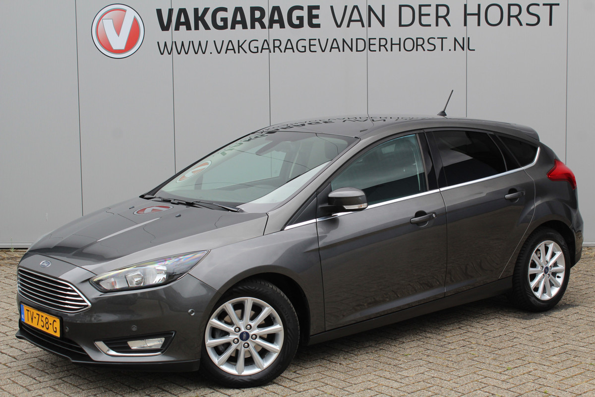 Ford Focus 1.0-125pk Titanium. Erg nette en luxe Ford Focus. Stoel-, stuur- en voorraamverw., autm. airco dual, navigatie, metallic lak, telefoonvoorb., camera, pdc v+a, dodehoek assist, AllSeason banden rondom, trekhaak, LM wielen etc.