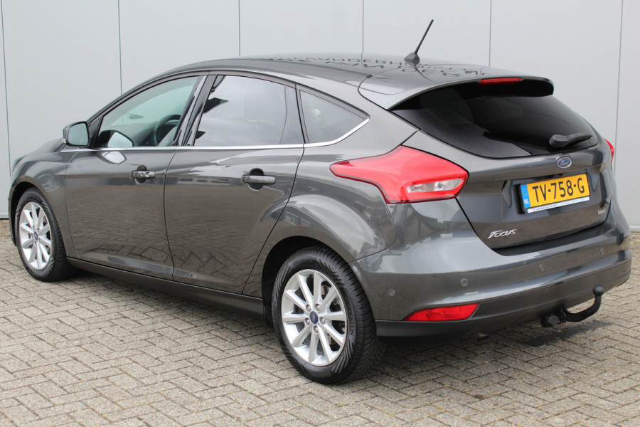 Ford Focus 1.0-125pk Titanium. Erg nette en luxe Ford Focus. Stoel-, stuur- en voorraamverw., autm. airco dual, navigatie, metallic lak, telefoonvoorb., camera, pdc v+a, dodehoek assist, AllSeason banden rondom, trekhaak, LM wielen etc.