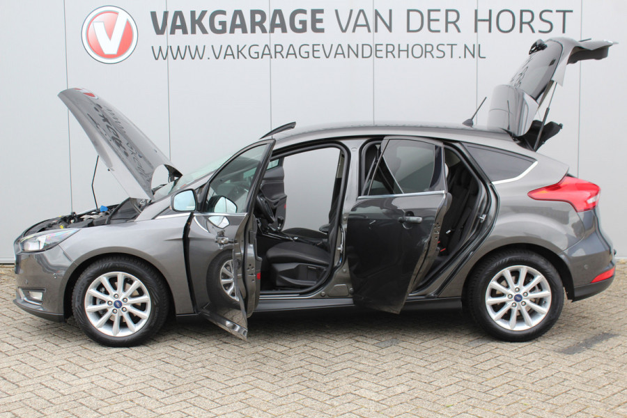 Ford Focus 1.0-125pk Titanium. Erg nette en luxe Ford Focus. Stoel-, stuur- en voorraamverw., autm. airco dual, navigatie, metallic lak, telefoonvoorb., camera, pdc v+a, dodehoek assist, AllSeason banden rondom, trekhaak, LM wielen etc.