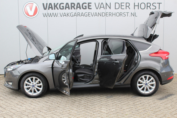 Ford Focus 1.0-125pk Titanium. Erg nette en luxe Ford Focus. Stoel-, stuur- en voorraamverw., autm. airco dual, navigatie, metallic lak, telefoonvoorb., camera, pdc v+a, dodehoek assist, AllSeason banden rondom, trekhaak, LM wielen etc.
