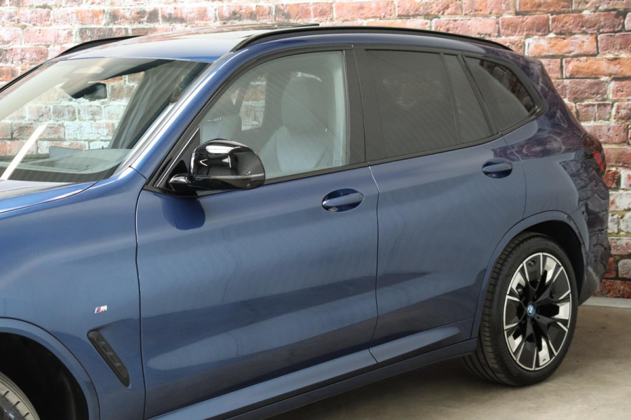 BMW iX3 High Executive M Sport Pakket 80 kWh / Live Cockpit Professional / Active Protection / Driving Assistant Professional / Panoramadak / Trekhaak / Leder / Adaptieve LED-koplamp / Shadow Line / Adaptief Onderstel /  Stuurwielverwarming / Head-Up Display / DAB / Harman Kardon