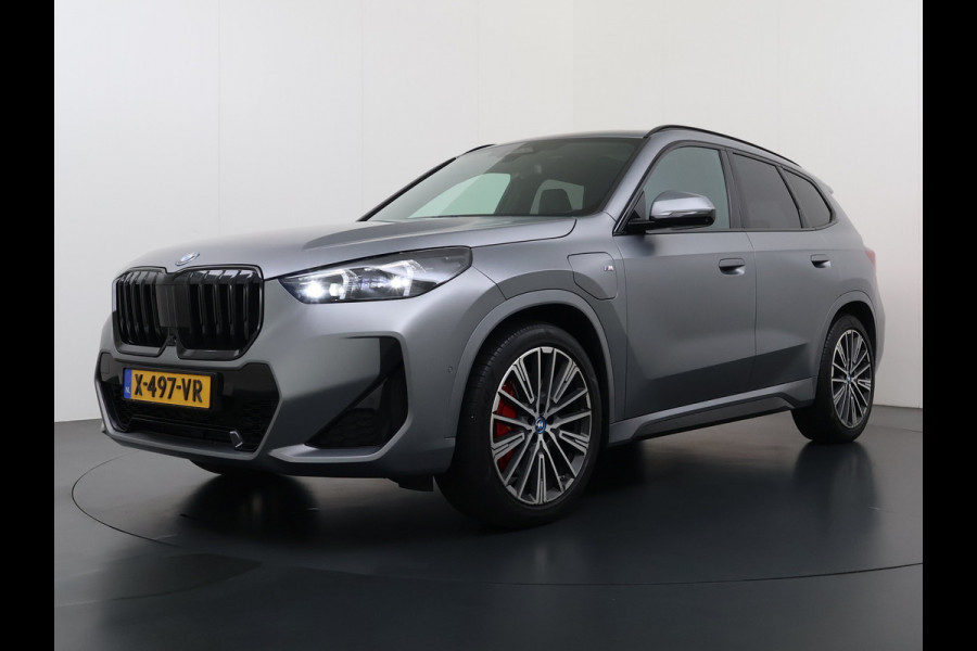 BMW X1 xDrive30e 327pk M-sport Leer Pano-Dak/Hef-Dak M-Sportstoelen+Elektr.+Geheugen+Verwarmd Trekhaak Harman-Kardon Adaptive-LED Live- Adaptive-Cruise AWD StuurVerwarmd Zwarte-Hemel Travelpack Park-Assist Pdc Draadloze lader Innovations-pakket Comfort-Pack €75.000,- Nieuw  Orig.NL auto! 1.800kg trekvermogen