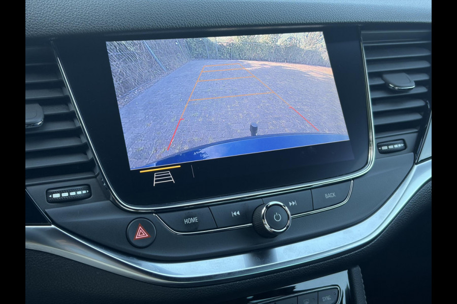 Opel Astra Sports Tourer 1.2 Ultimate 2e Eigenaar l Trekhaak l Camera l Carplay l Navi l Alcantara-Leder l 17''Lmv l Stoelverw-Stuurverw l Net beurt gehad l Dodehoek l Rijstrooksensor l Pdc V+A l 6 Bak l N.A.P l 146pk l Bj 11-2020 l Apk tot 08-2028