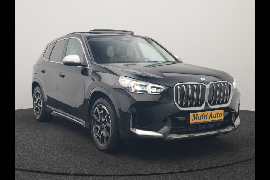 BMW iX1 xDrive30 X Line 67 kWh 313pk Dealer O.H. | Trekhaak Af Fabriek | Panodak | Head Up | Adaptive Cruise | 360 Camera | Harman / Kardon | Lederen Sportstoelen Massage & Memory | Keyless | Sfeerverlichting | Stoelen & Stuur Verwarmd | Apple Carplay | Widescreen Navi | DAB | 19"L.M |