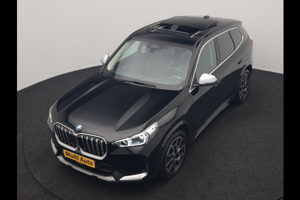 BMW iX1 xDrive30 X Line 67 kWh 313pk Dealer O.H. | Trekhaak Af Fabriek | Panodak | Head Up | Adaptive Cruise | 360 Camera | Harman / Kardon | Lederen Sportstoelen Massage & Memory | Keyless | Sfeerverlichting | Stoelen & Stuur Verwarmd | Apple Carplay | Widescreen Navi | DAB | 19"L.M |