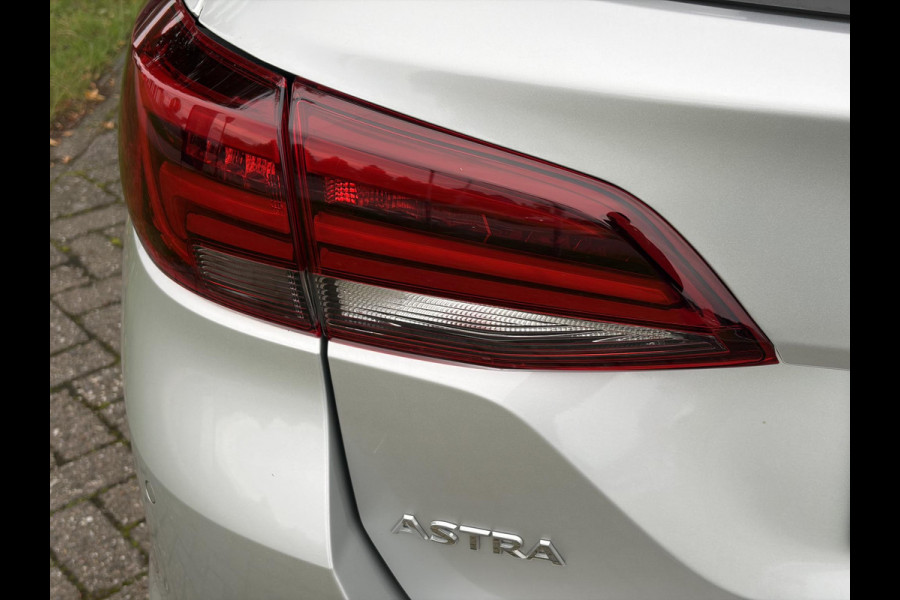 Opel Astra Sports Tourer 1.2 Elegance ✓110pk✓Camera✓Carplay✓Navi✓Halfleder✓Keyless✓Trekhaak✓Pdc V+A✓Clima✓Cruise✓Elekt Stoel✓Recent beurt gehad✓Dodehoeksensor✓Rijstrooksensor✓Lm velgen✓N.A.P✓Apk tot 11-2027
