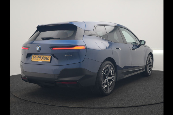 BMW iX xDrive40 Excellence 77 kWh 327pk | SOH 96,9% | Trekhaak Af Fabriek | Panodak Sky Lounge | Adaptive Cruise | Head Up | 360 Camera | Harman / Kardon | Lederen Sportstoelen & Stuur Verwarmd | Sfeerverlichting | BLIS | Keyless |