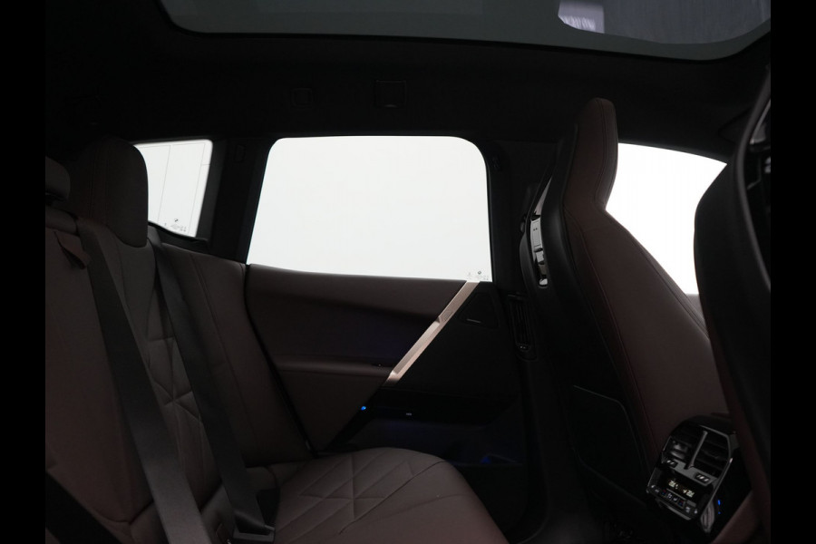 BMW iX xDrive40 Excellence 77 kWh 327pk | SOH 96,9% | Trekhaak Af Fabriek | Panodak Sky Lounge | Adaptive Cruise | Head Up | 360 Camera | Harman / Kardon | Lederen Sportstoelen & Stuur Verwarmd | Sfeerverlichting | BLIS | Keyless |