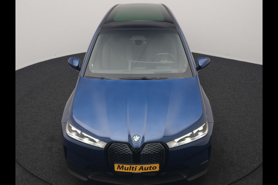 BMW iX xDrive40 Excellence 77 kWh 327pk | SOH 96,9% | Trekhaak Af Fabriek | Panodak Sky Lounge | Adaptive Cruise | Head Up | 360 Camera | Harman / Kardon | Lederen Sportstoelen & Stuur Verwarmd | Sfeerverlichting | BLIS | Keyless |