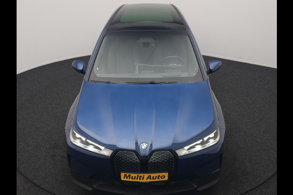 BMW iX xDrive40 Excellence 77 kWh 327pk | SOH 96,9% | Trekhaak Af Fabriek | Panodak Sky Lounge | Adaptive Cruise | Head Up | 360 Camera | Harman / Kardon | Lederen Sportstoelen & Stuur Verwarmd | Sfeerverlichting | BLIS | Keyless |