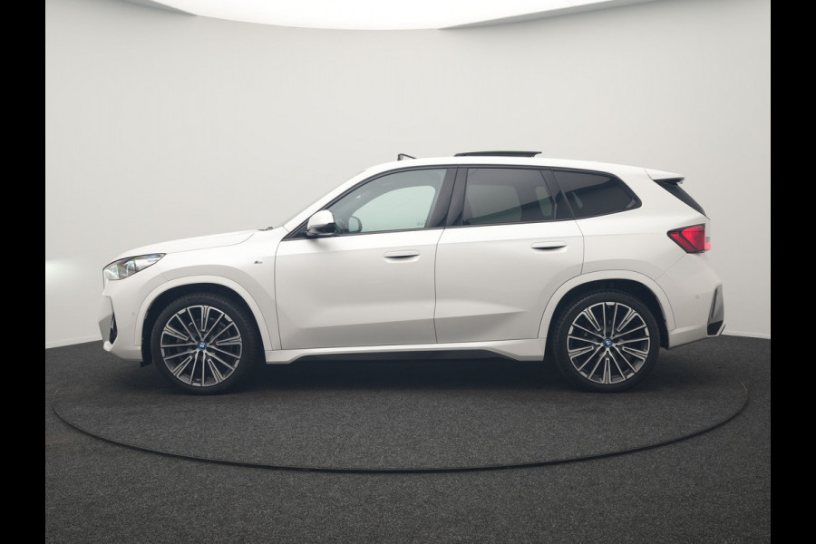 BMW iX1 xDrive30 M Sport 313pk Dealer O.H. | Trekhaak Af Fabriek | Panodak | 360 Camera | Head Up | Lederen Sportstoelen Memory & Verwarmd | Stuur Verwarmd | Keyless | BLIS | Sfeerverlichting | Apple Carplay | Navigatie | DAB | 20"L.M
