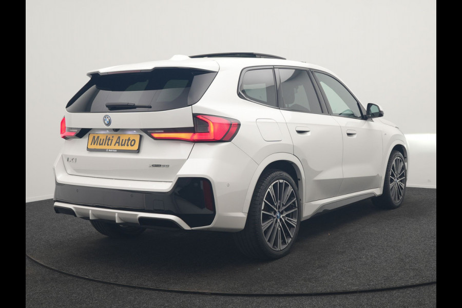 BMW iX1 xDrive30 M Sport 313pk Dealer O.H. | Trekhaak Af Fabriek | Panodak | 360 Camera | Head Up | Lederen Sportstoelen Memory & Verwarmd | Stuur Verwarmd | Keyless | BLIS | Sfeerverlichting | Apple Carplay | Navigatie | DAB | 20"L.M