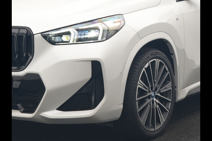 BMW iX1 xDrive30 M Sport 313pk Dealer O.H. | Trekhaak Af Fabriek | Panodak | 360 Camera | Head Up | Lederen Sportstoelen Memory & Verwarmd | Stuur Verwarmd | Keyless | BLIS | Sfeerverlichting | Apple Carplay | Navigatie | DAB | 20"L.M