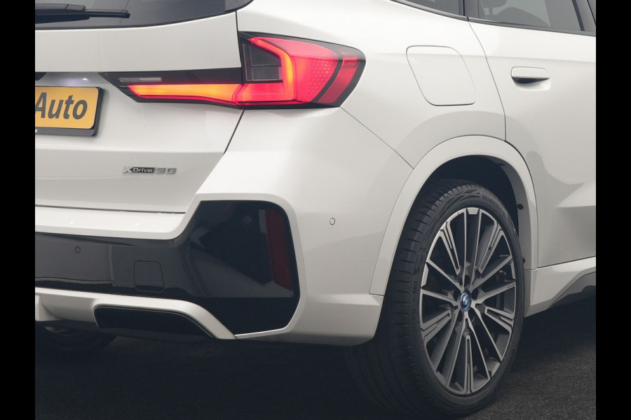 BMW iX1 xDrive30 M Sport 313pk Dealer O.H. | Trekhaak Af Fabriek | Panodak | 360 Camera | Head Up | Lederen Sportstoelen Memory & Verwarmd | Stuur Verwarmd | Keyless | BLIS | Sfeerverlichting | Apple Carplay | Navigatie | DAB | 20"L.M