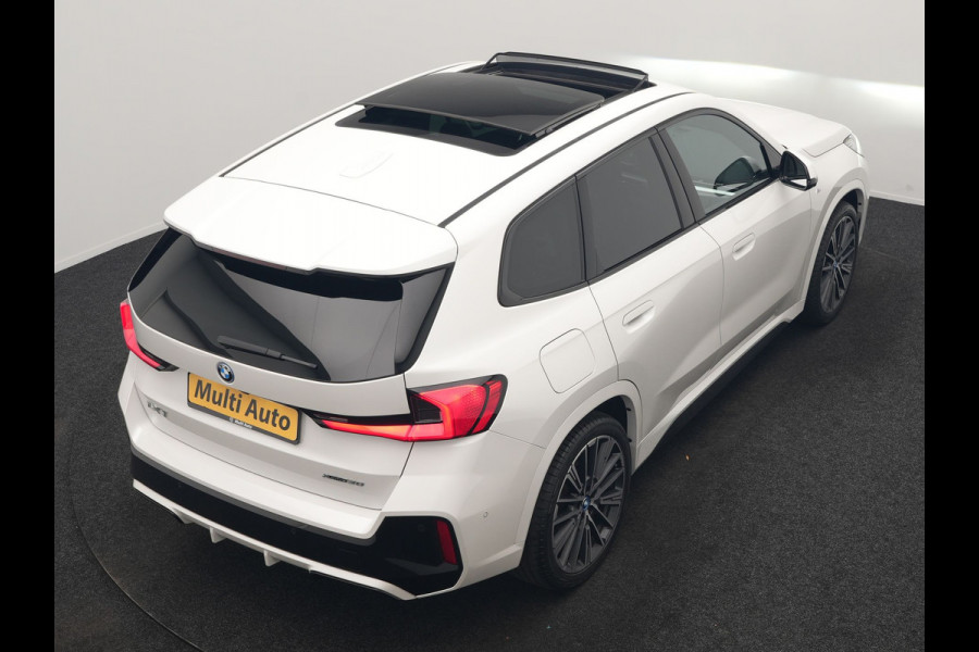 BMW iX1 xDrive30 M Sport 313pk Dealer O.H. | Trekhaak Af Fabriek | Panodak | 360 Camera | Head Up | Lederen Sportstoelen Memory & Verwarmd | Stuur Verwarmd | Keyless | BLIS | Sfeerverlichting | Apple Carplay | Navigatie | DAB | 20"L.M