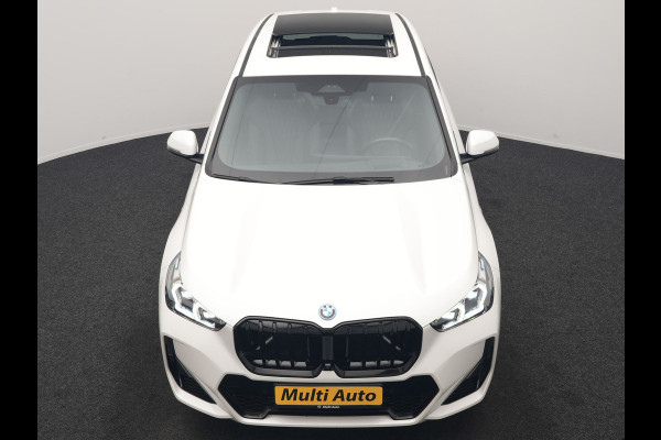 BMW iX1 xDrive30 M Sport 313pk Dealer O.H. | Trekhaak Af Fabriek | Panodak | 360 Camera | Head Up | Lederen Sportstoelen Memory & Verwarmd | Stuur Verwarmd | Keyless | BLIS | Sfeerverlichting | Apple Carplay | Navigatie | DAB | 20"L.M