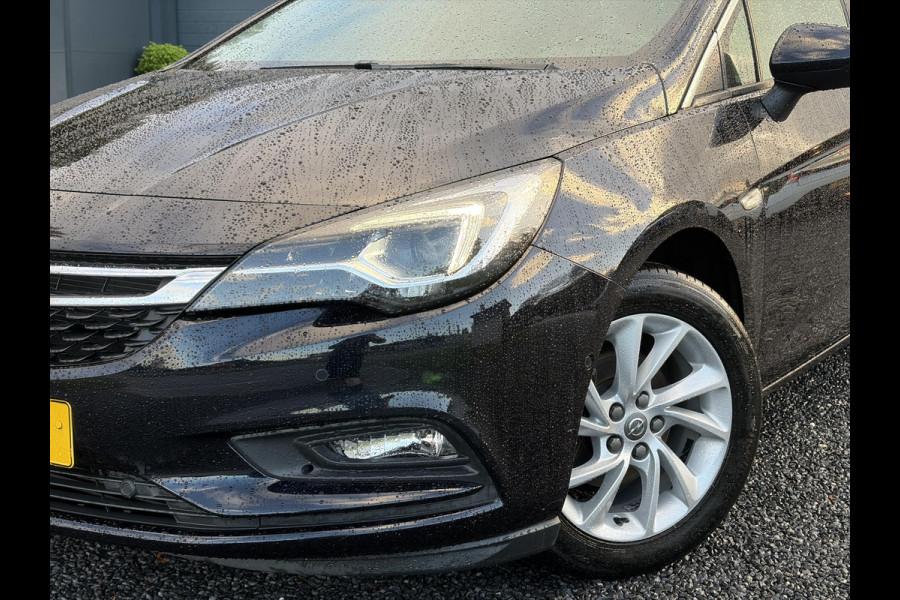 Opel Astra Sports Tourer 1.4 Innovation ✓Trekhaak✓Camera✓Carplay✓Navi✓Recent beurt gehad✓150pk✓Keyless✓Halfleder✓6 Bak✓Rijstrooksensor✓Dodehoeksensor✓Pdc V+A✓Lm velgen✓Clima✓Cruise✓N.A.P✓Apk tot 09-2027