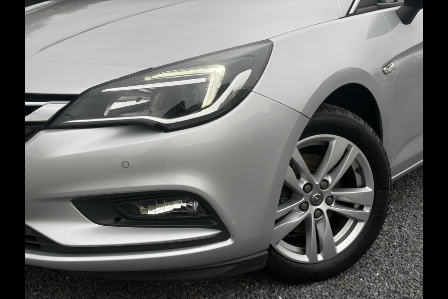 Opel Astra Sports Tourer 1.4 Online Edition ✓2e Eigenaar✓Trekhaak✓Carplay✓Navi✓Recent beurt gehad✓150pk✓Dealer Onderhouden✓6 Bak✓Pdc V+A✓Lm velgen✓Clima✓Cruise✓N.A.P✓Apk tot 06-2027